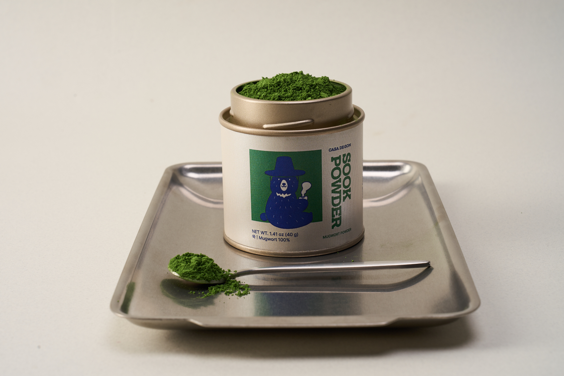 Sook Powder tin open with a spoon of mugwort powder